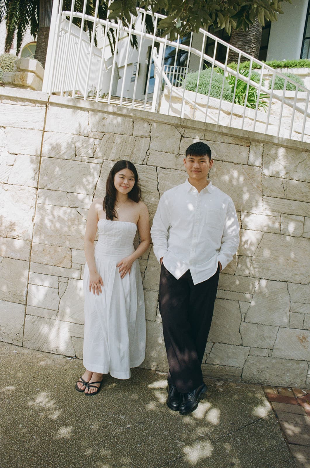 Kobe and Chesqa standing against a stone wall